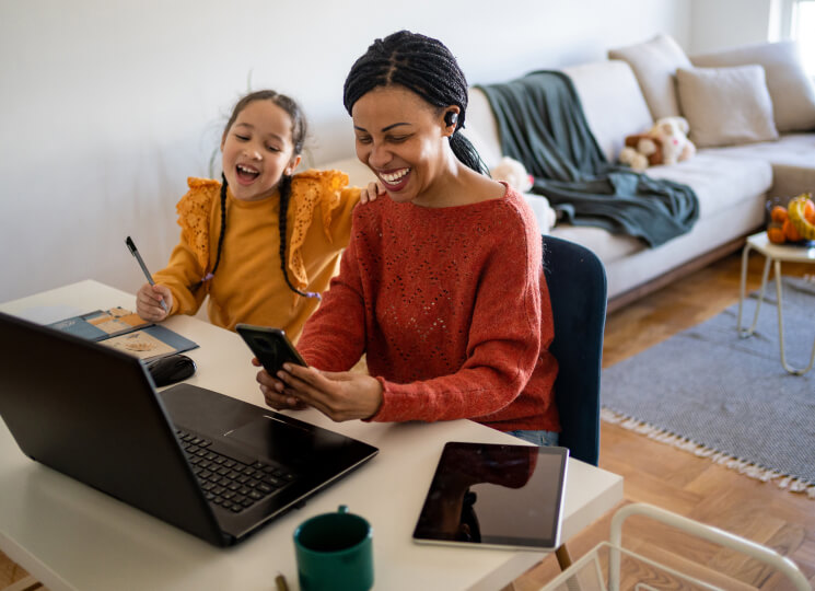 mother and daughter with phones and laptop